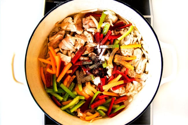 Lighter ONE POT Chicken Fajita Pasta has only minutes of hands-on cooking time! Its smothered in cheesy, creamy salsa infused sauce bursting with your favorite fajita spiced chicken, onions and peppers! The pasta cooks right IN the sauce for simple prep, minimal cleanup, and extra flavooooor! showing how to make chicken fajita pasta by adding chicken, bell peppers, onions and fajita seasonings to a large pot