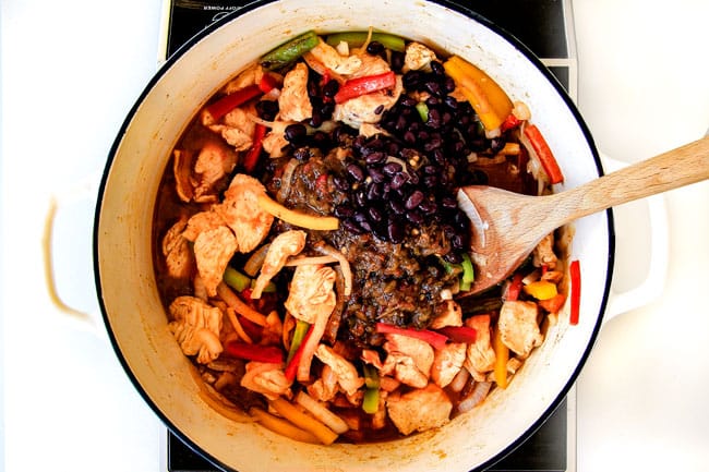 Lighter ONE POT Chicken Fajita Pasta has only minutes of hands-on cooking time! Its smothered in cheesy, creamy salsa infused sauce bursting with your favorite fajita spiced chicken, onions and peppers! The pasta cooks right IN the sauce for simple prep, minimal cleanup, and extra flavooooor! showing how to make easy chicken fajita pasta by adding black beans to chicken, bell peppers and onions