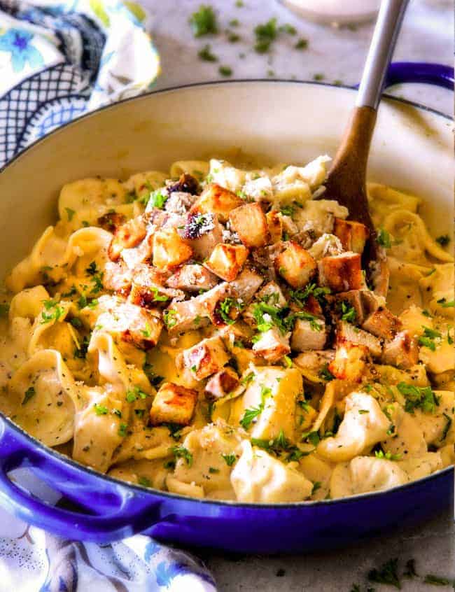 Caesar Chicken Tortellini with a wood spoon.