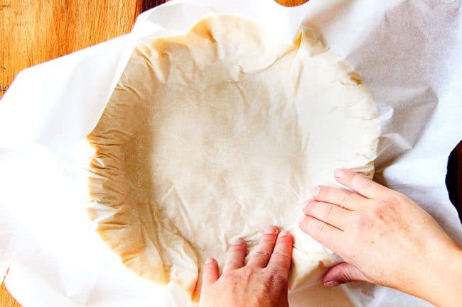 showing how to make pie crust by flipping dough into a pie plate
