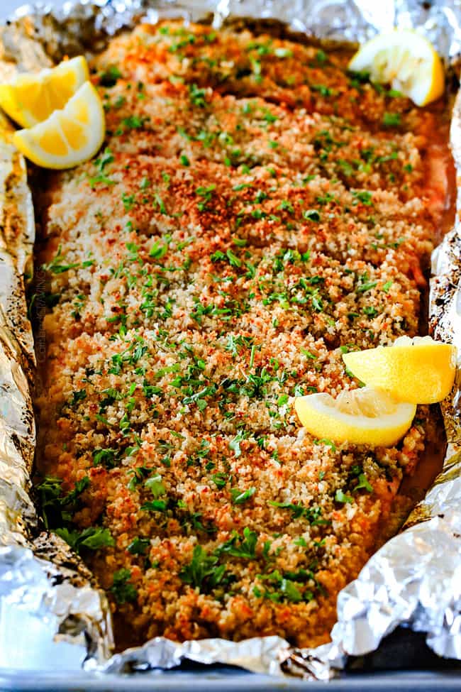 25 MINUTE Baked Lemon Garlic Butter Salmon with Crispy Parmesan Panko & Broccoli! This salmon is not only bursting with flavor and sooo juicy and tender but the easiest, most satisfying meal that tastes totally gourmet! My parents were blown away by this meal! front view of oven baked salmon garnished with parsley