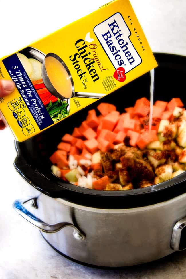 this SUPER creamy Slow Cooker Chipotle Sweet Potato Soup is AMAZING! Its loaded with flavor, gluten free, dairy free, crazy healthy and so easy! Definitely one of my new favorite soups! showing how to make Sweet Potato Soup by pouring chicken broth into the pot with sweet potatoes and spices