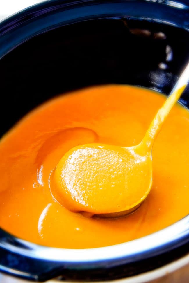 this SUPER creamy Slow Cooker Chipotle Sweet Potato Soup is AMAZING! Its loaded with flavor, gluten free, dairy free, crazy healthy and so easy! Definitely one of my new favorite soups! a ladle full of creamy Sweet Potato Soup