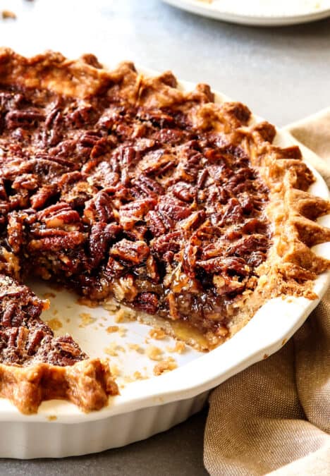 up close side view of pecan pie recipe in the pie plate with a piece missing showing the texture if the filling
