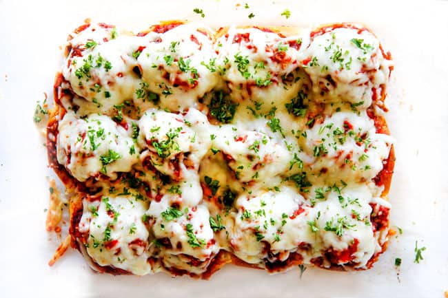 These Cheesy Italian Meatball Sliders are my favorite party food ever and my family loves them for dinner! The meatballs are the BEST (so tender and juicy!) and the marinara is amazing and I love how they are individual sliders instead of meatball subs! I can't recommend these enough! showing how to make meatball sliders by baking sliders until cheese melts