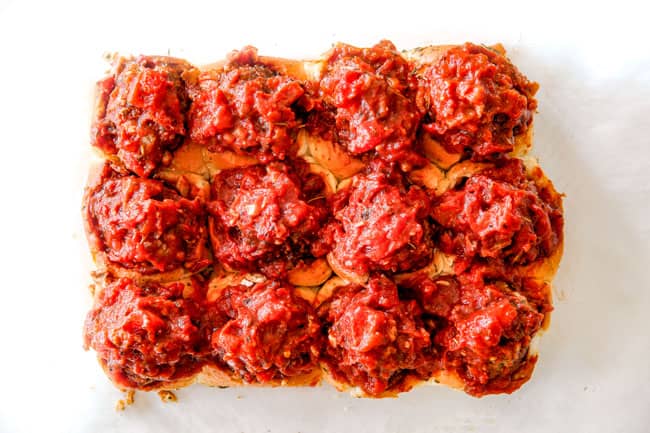 These Cheesy Italian Meatball Sliders are my favorite party food ever and my family loves them for dinner! The meatballs are the BEST (so tender and juicy!) and the marinara is amazing and I love how they are individual sliders instead of meatball subs! I can't recommend these enough! showing how to make meatball sliders by stuffing Italian meatballs into Hawaiian rolls