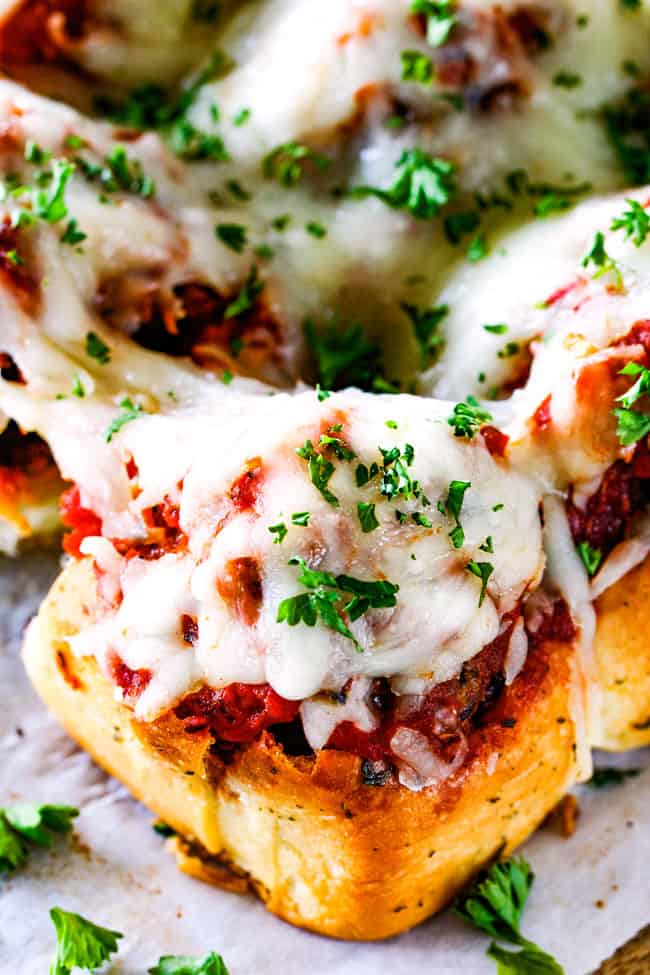 These Cheesy Italian Meatball Sliders are my favorite party food ever and my family loves them for dinner! The meatballs are the BEST (so tender and juicy!) and the marinara is amazing and I love how they are individual sliders instead of meatball subs! I can't recommend these enough! top up close view of best meatball slider on a Hawaiian roll
