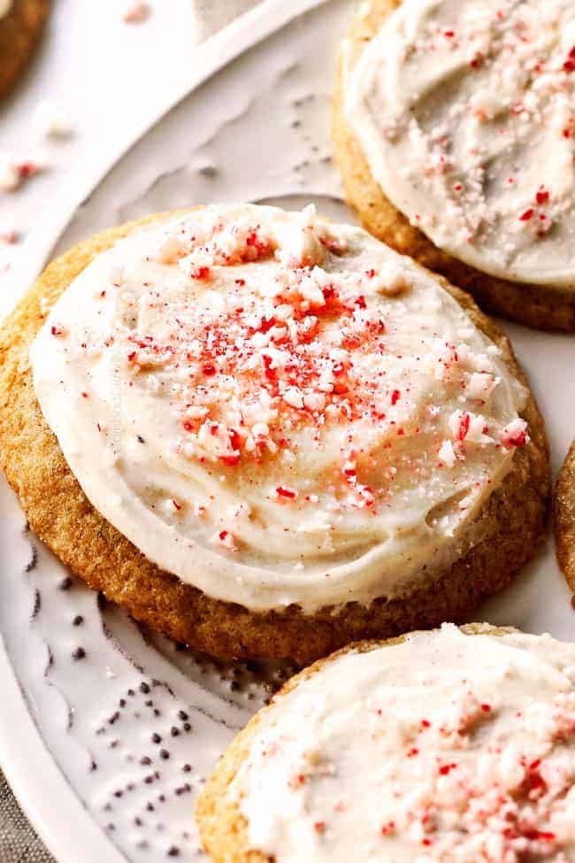 close up of eggnog cookies topped with eggnog frosted and crushed candy canes.