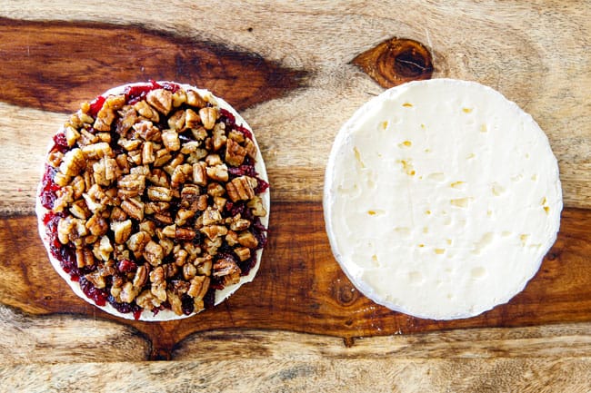 Rich and creamy Baked Brie in Puff Pastry is always a total luxuriously tasting crowd pleaser with minimal effort! (step by step pictures included) It can be prepped in advance then baked when you're ready for company! aaaaaaaaa showing how to make baked brie in puff pastry by adding pecans to top of jam