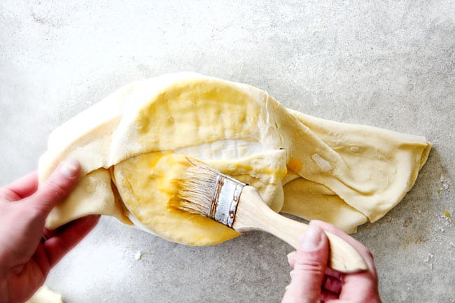 Rich and creamy Baked Brie in Puff Pastry is always a total luxuriously tasting crowd pleaser with minimal effort! (step by step pictures included) It can be prepped in advance then baked when you're ready for company! showing how to fold baked brie in puff pastry