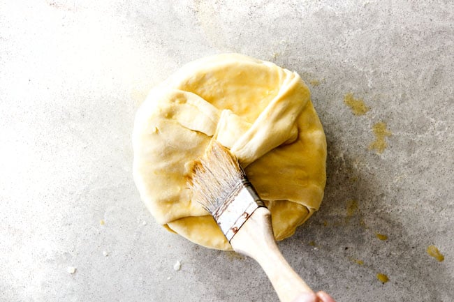 Rich and creamy Baked Brie in Puff Pastry is always a total luxuriously tasting crowd pleaser with minimal effort! (step by step pictures included) It can be prepped in advance then baked when you're ready for company! brushing baked brie in puff pastry with egg wash
