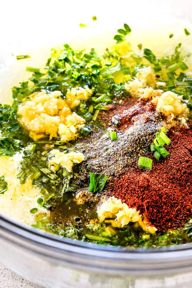 showing how to make Hasselback potatoes by mixing garlic thyme butter ingredients together in a glass bowl