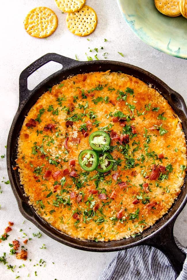 top view of Jalapeno Popper Dip with Bacon in a cast iron skillet with parsley and crackers