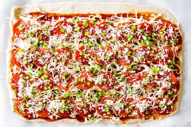 These Pizza Pinwheels are super easy to make, customizable, freeze beautifully, and absolutely irresistible for snacks, appetizers or fun meals! You friends and family will beg you to make these! showing how to make pizza pinwheels by adding cheese and bell peppers