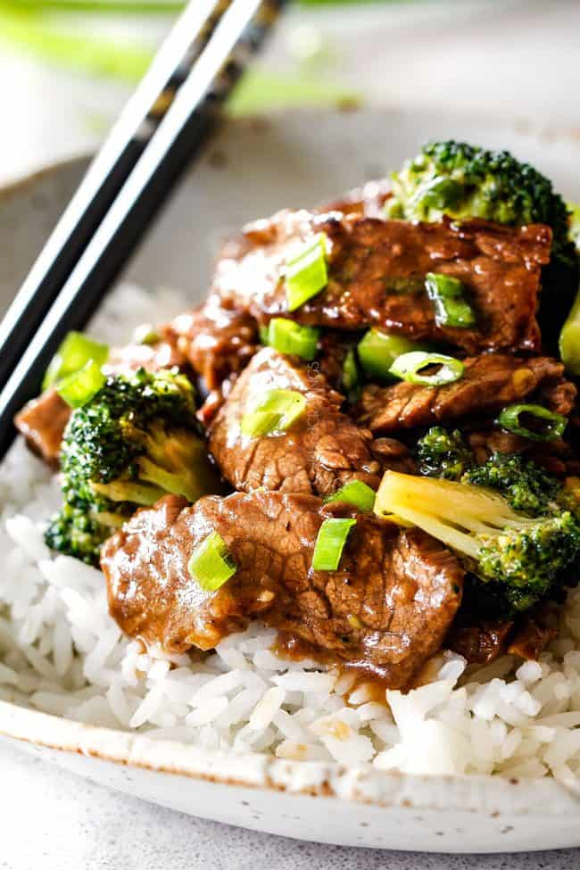 beef and broccoli with white rice and chopsticks