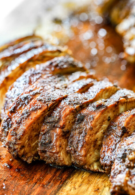 showing how to make Greek Chicken Salad by slicing chicken on a cutting board