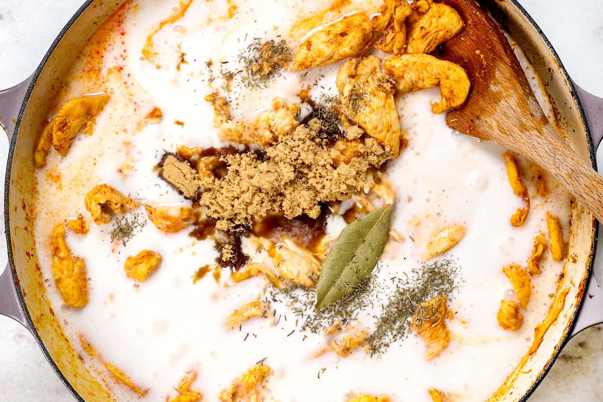 showing how to make panang curry by adding coconut milk, lime juice, bay leaf and thyme.