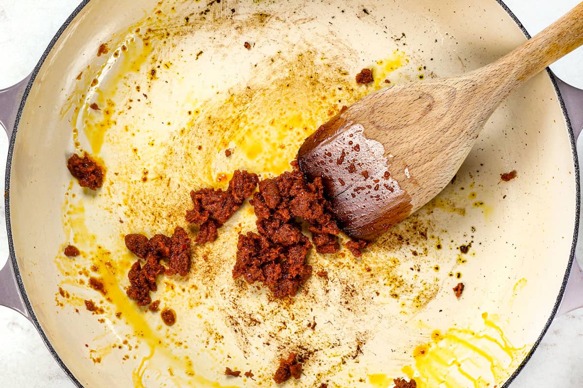 showing how to make panang curry by blooming the panang curry paste in oil