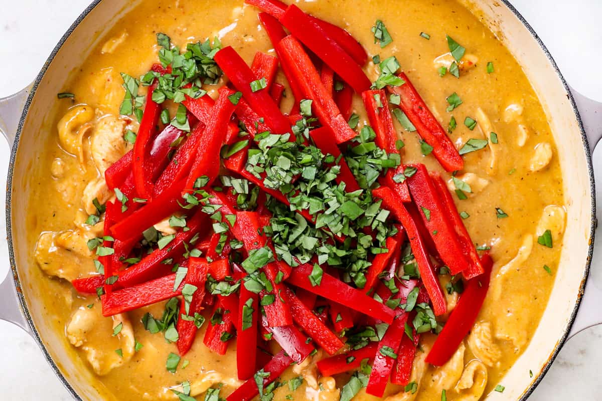 showing how to make panang curry recipe by adding vegetables and basil
