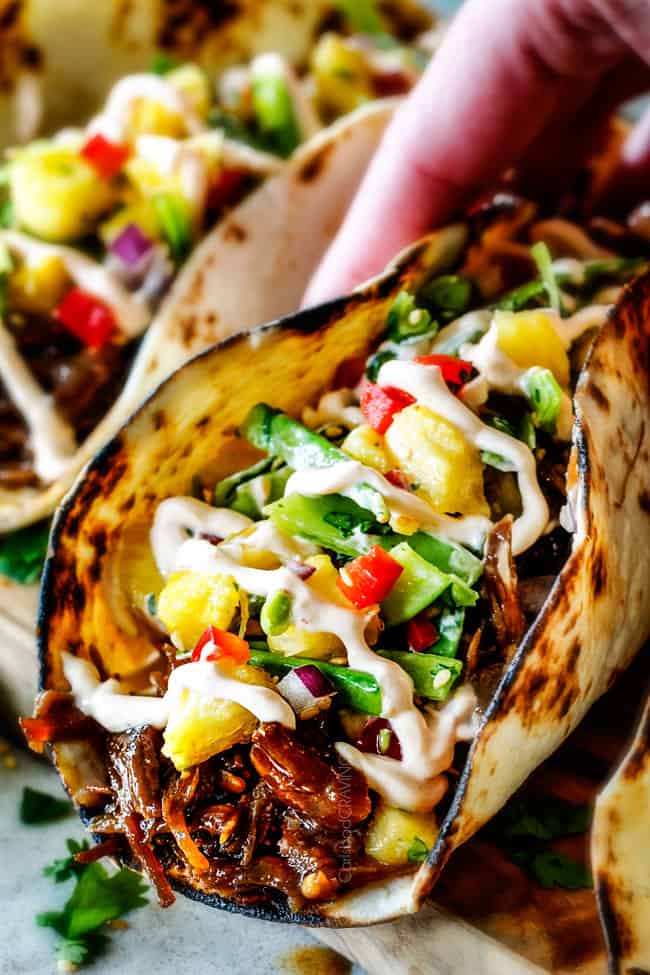 pulled pork in a taco with pineapple and lettuce