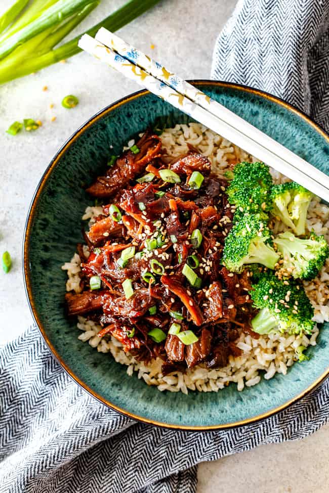 eating pulled pork in a green bowl with chopsticks