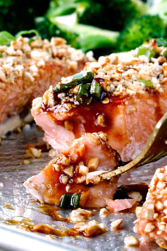 Honey Soy Salmon crusted in cashews on a baking sheet with a fork
