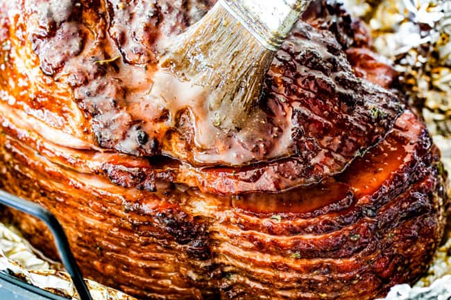 Showing how to Cook a Precooked Ham by slathering ham with Brown Sugar Glaze for Ham after ham surface is caramelized