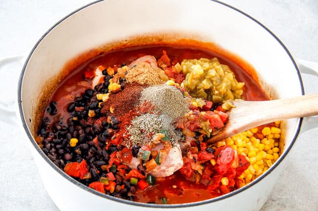 Easy 30-Minute Homemade Chicken Tortilla Soup that tastes better than any restaurant! It's accidentally healthy, easy to double/triple for a crowd, freezer friendly and tastes like it's been simmering for hours but on your table in 30 Minutes! Showing How to Make Mexican Chicken Tortilla Soup recipe by adding chicken, fire diced tomatoes, black beans, corn, enchilada sauce, chicken broth, chili powder, cumin, smoked paprika, dried oregano, salt and pepper to white Dutch oven