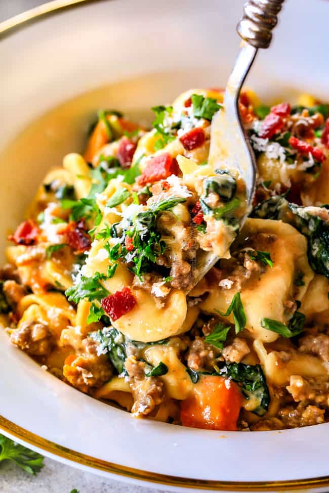 Howto make Creamy Tortellini by cooking Italian sausage in a skillet with onions and sweet potatoes