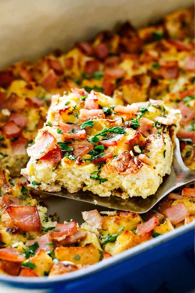 up close shot of a piece of Eggs Benedict Casserole being raised from blue casserole dish