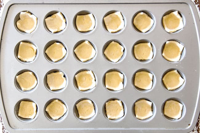 Showing how to make Artichoke Dip Bites by placing puff pastry squares in mini muffin tin