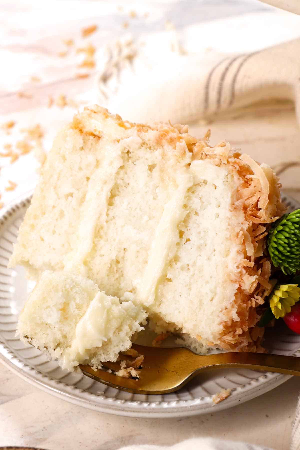 a slice of coconut cream cake on its side showing the layers of frosting