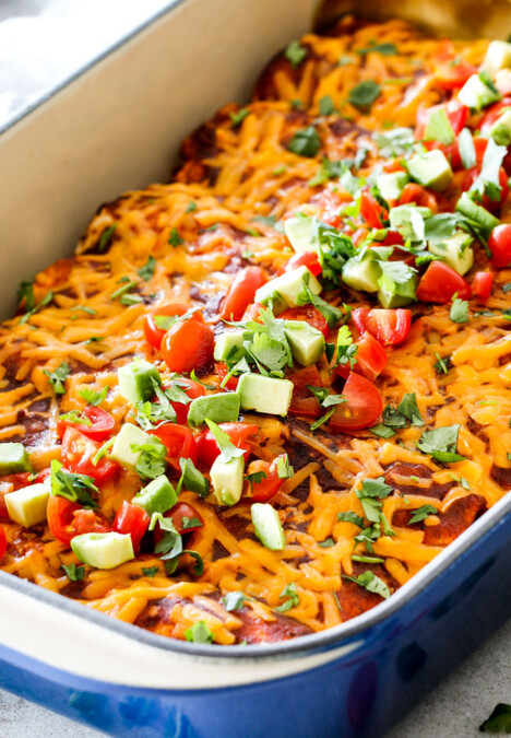up close of cheesy Beef Enchiladas in a white baking dish