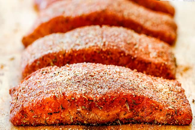 Cajun Salmon on a wood cutting board with homemade cajun seasoniong