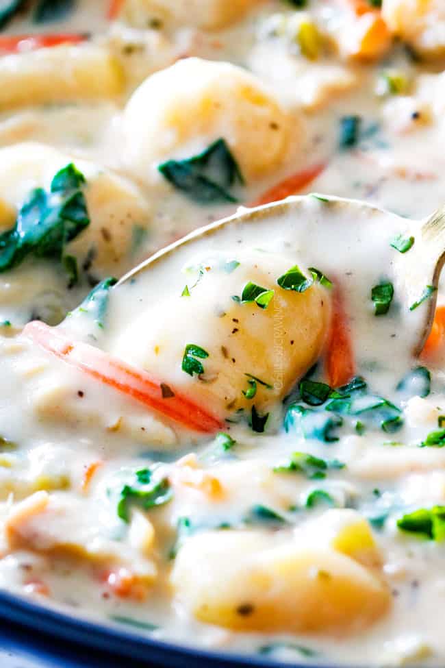 up close of Chicken Gnocchi Soup with one potato gnocchi in a silver spoon