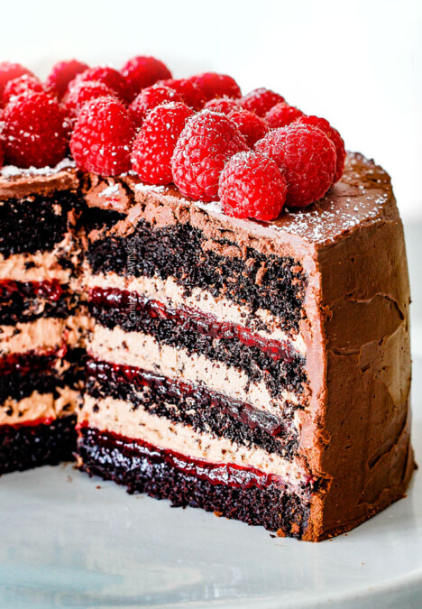 Chocolate Raspberry Cake with sliced removed showing layers of dark chocolate cake, raspberry jam filling, chocolate ganache and chocolate mousse