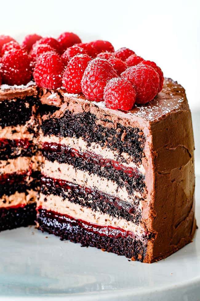 Chocolate Raspberry Cake with sliced removed showing layers of dark chocolate cake, raspberry jam filling, chocolate ganache and chocolate mousse