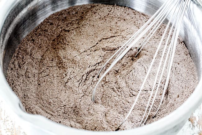 making Chocolate Raspberry Ganache Cake by whisking together dry ingredients