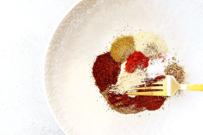 Showing how to make easy Shrimp Fajitas by mixing together homemade fajita seasoning in a white bowl