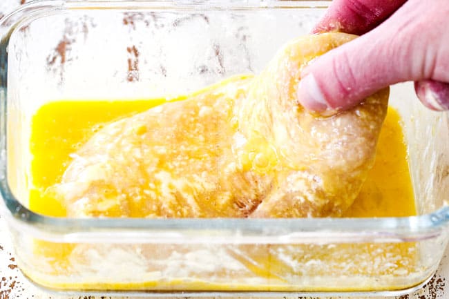 showing how to make easy chicken Parmesan by dipping chicken in egg wash in a glass shallow dish