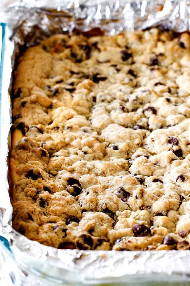 Chocolate Chip Cheesecake Bars in a 9x13glass pan waiting to be sliced