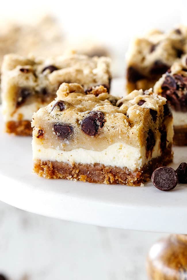 Chocolate Chip Cheesecake Bars on a white pedestal