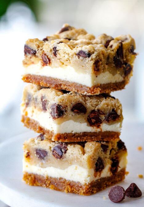 stack of cookie dough cheesecake bars with graham cracker crust, cheesecake and cookie dough