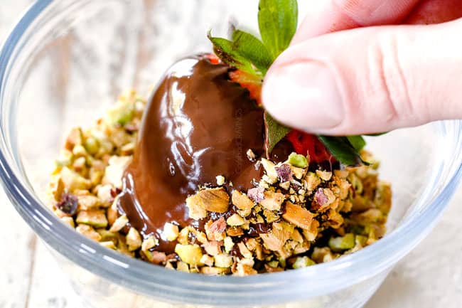 Rolling chocolate covered strawberry in pistachios