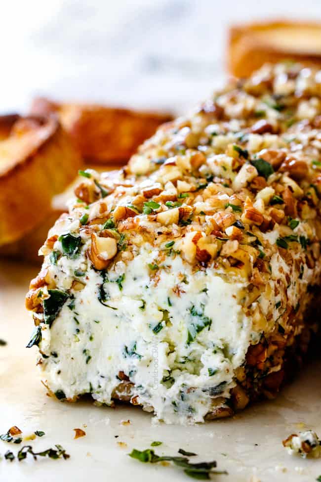 side shot of goat cheese log with garlic, lemon zest, basil, chives, parsley and rolled in pecans
