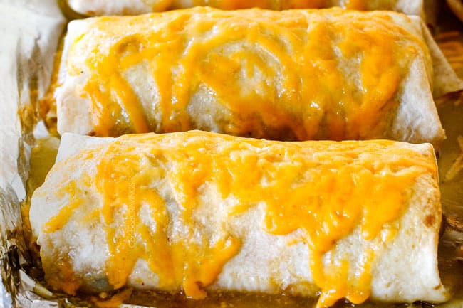 showing how to make wet burritos by melting smothering in enchilada sauce and cheese