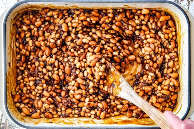 Showing How to make Boston Baked Beans by stirring navy and pinto beans together with homemade sauce