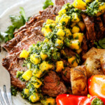 Chimichurri steak sliced on a plate with chimichurri