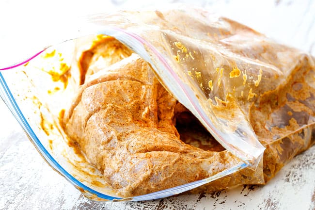 showing how to make Tandoori Chicken by adding chicken to marinade in a plastic bag