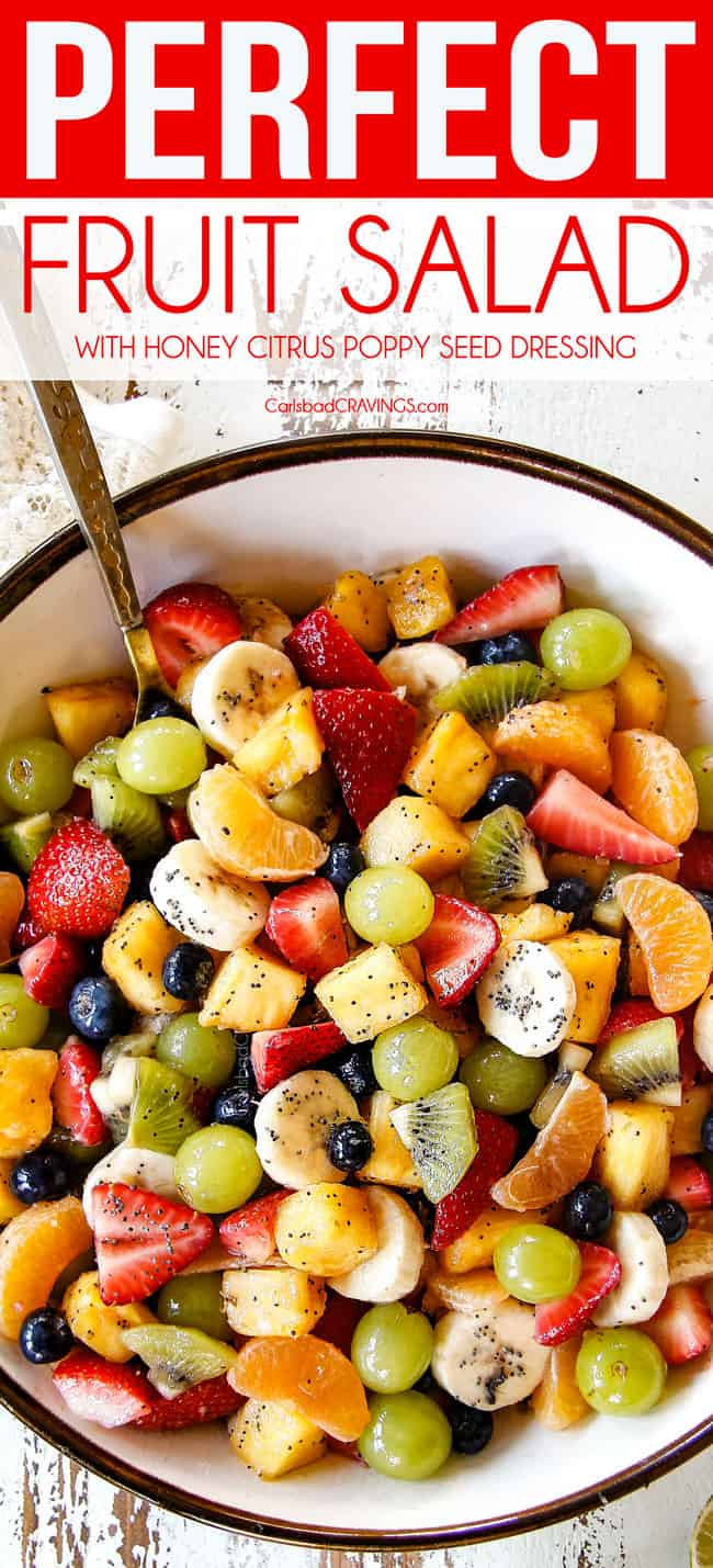 top view of best fruit salad in bowl with pineapple, strawberries, blueberries, bananas, kiwis, grapes and oranges
